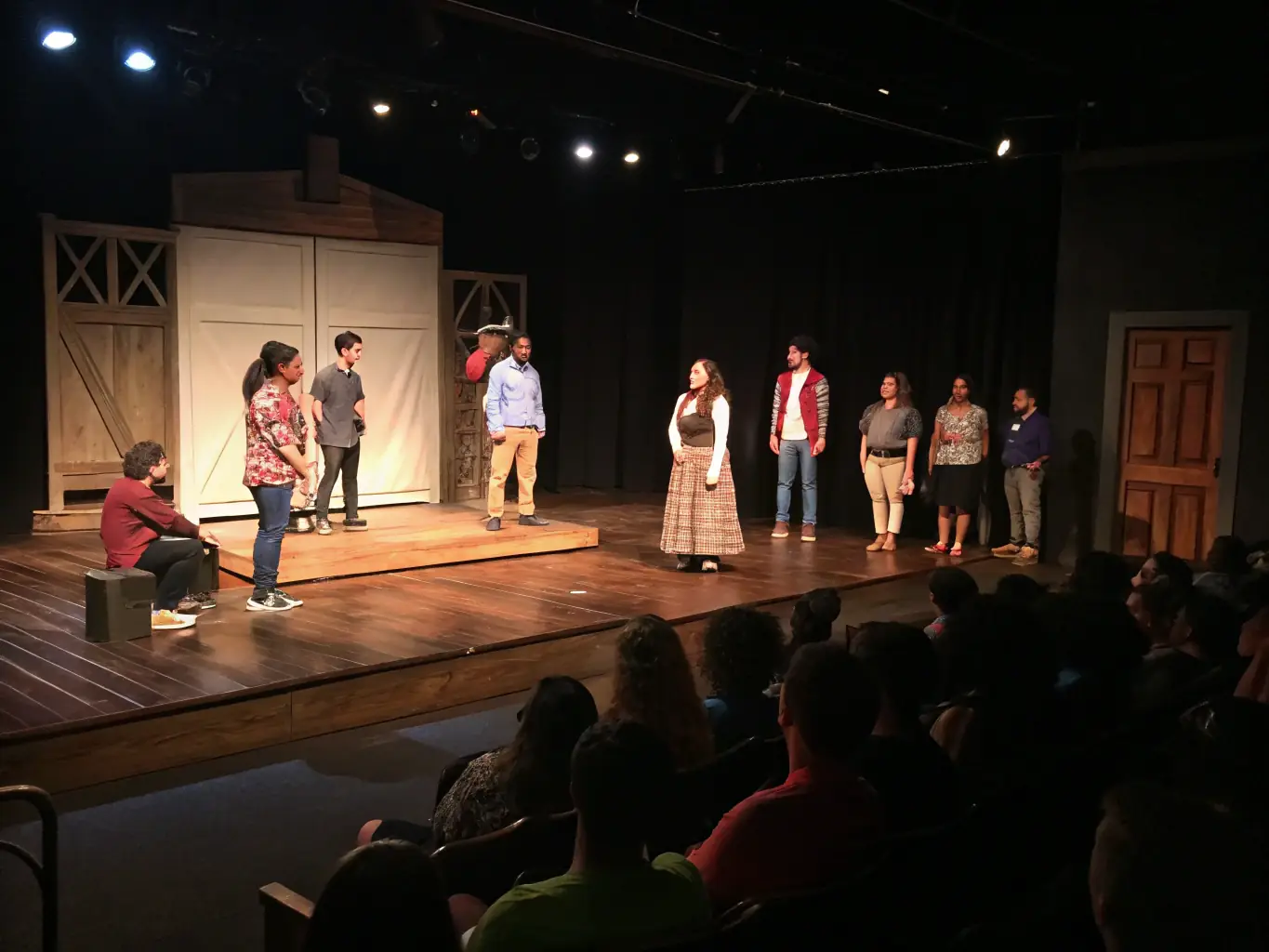 A scene from a theatrical performance organized by ADAGIO PROD, featuring amateur actors showcasing their talents on stage in a community theater setting.